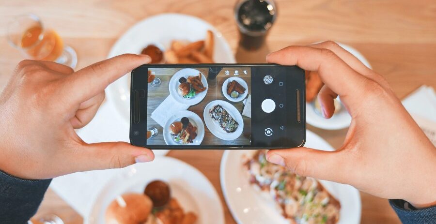 eaters-collective-i_xVfNtQjwI-unsplash person taking photo of food on iphone